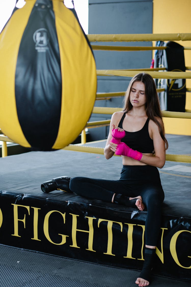 Woman Training Kickboxing Sitting In Gym