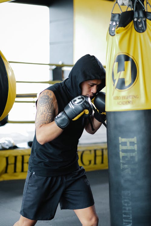 Free A Man Wearing a Hoodie Tank Top while Training Inside the Boxing Gym Stock Photo