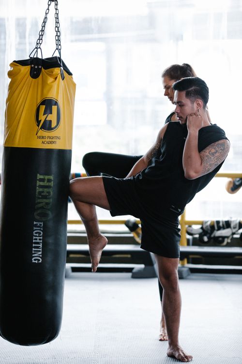 Free Man practicing kickboxing with female trainer in a gym session. Stock Photo