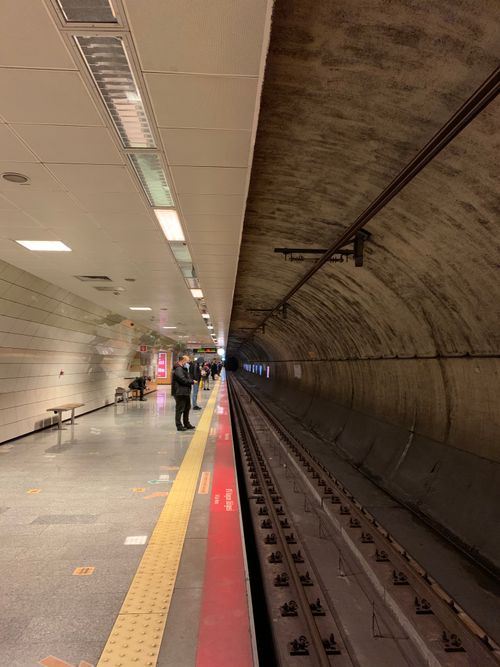 Free A modern metro station platform leading into a symmetrical subway tunnel. Stock Photo