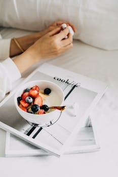 A fresh and healthy breakfast bowl with berries over a book, perfect for a cozy morning start.