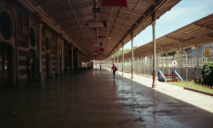 Person Walking Along Empty Train Platform