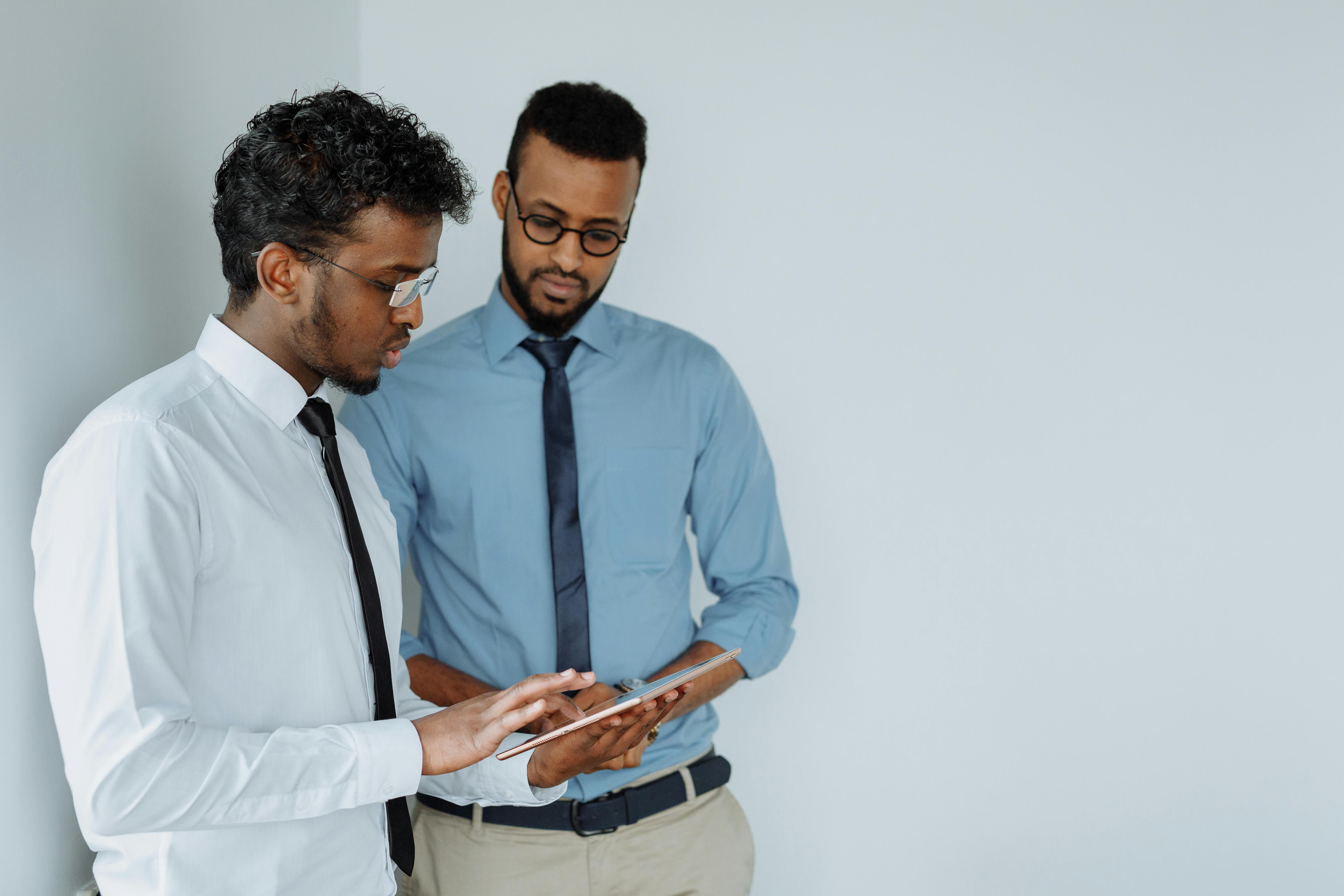 men using tablet while having discussion