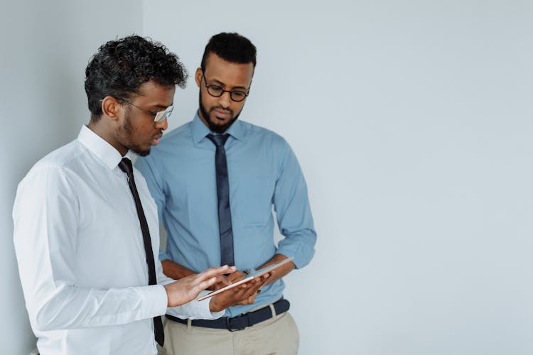 Men Using Tablet While Having Discussion