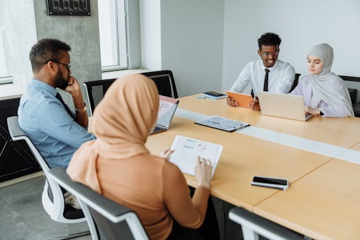 A diverse group of professionals having a meeting in a modern office setting, showcasing teamwork and collaboration.