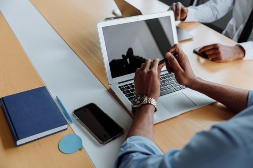 Free Close-up of a business meeting with laptops and smartphones, focusing on teamwork and digital collaboration. Stock Photo