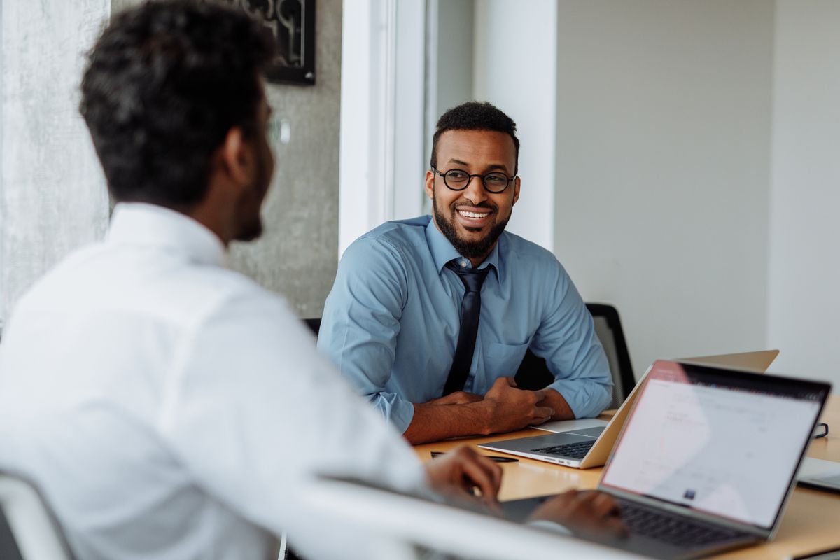 Two colleagues engaged in a friendly discussion at the office