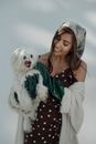 A Woman Wearing Gloves Holding a Dog