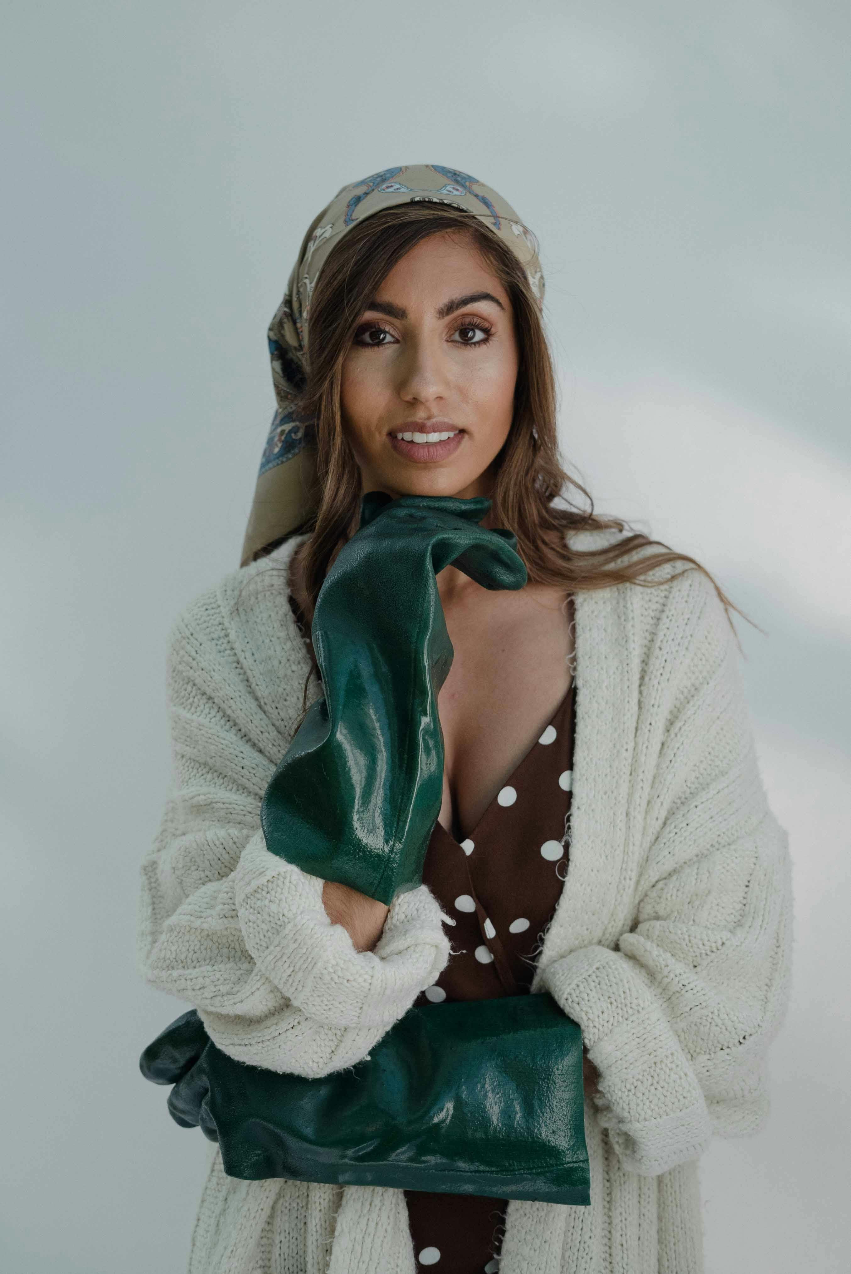 a beautiful woman posing while wearing green gloves