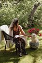 A Woman Wearing a Polka Dot Dress Petting a Dog