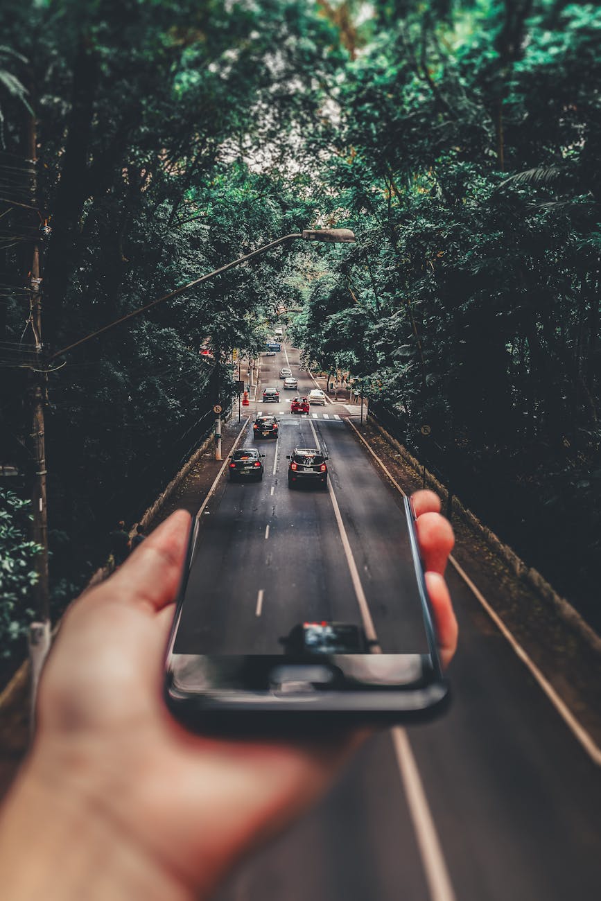 Buying cars online, cars emerging from a phone onto a road