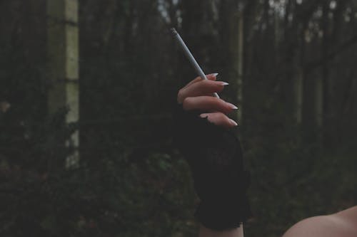 Hand Holding a Lighted Cigarette