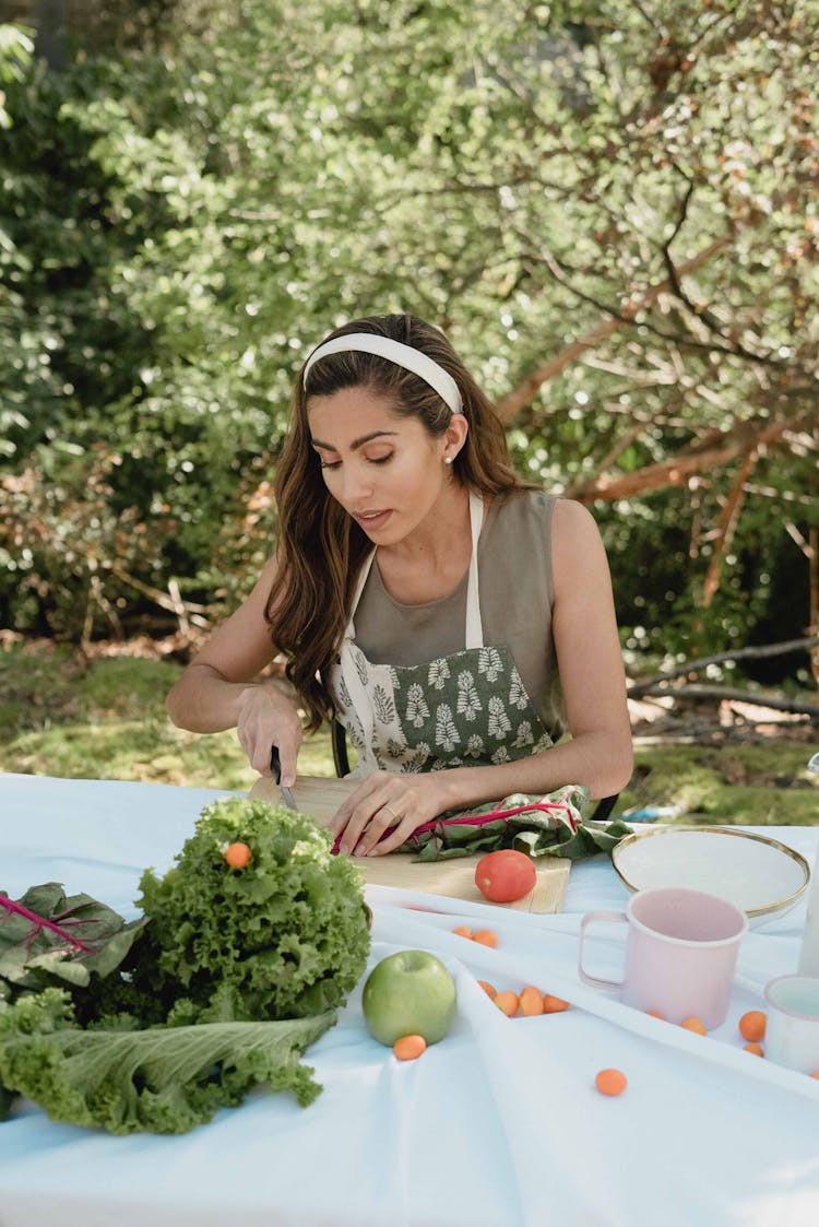 A Woman Slicing A Vegetable