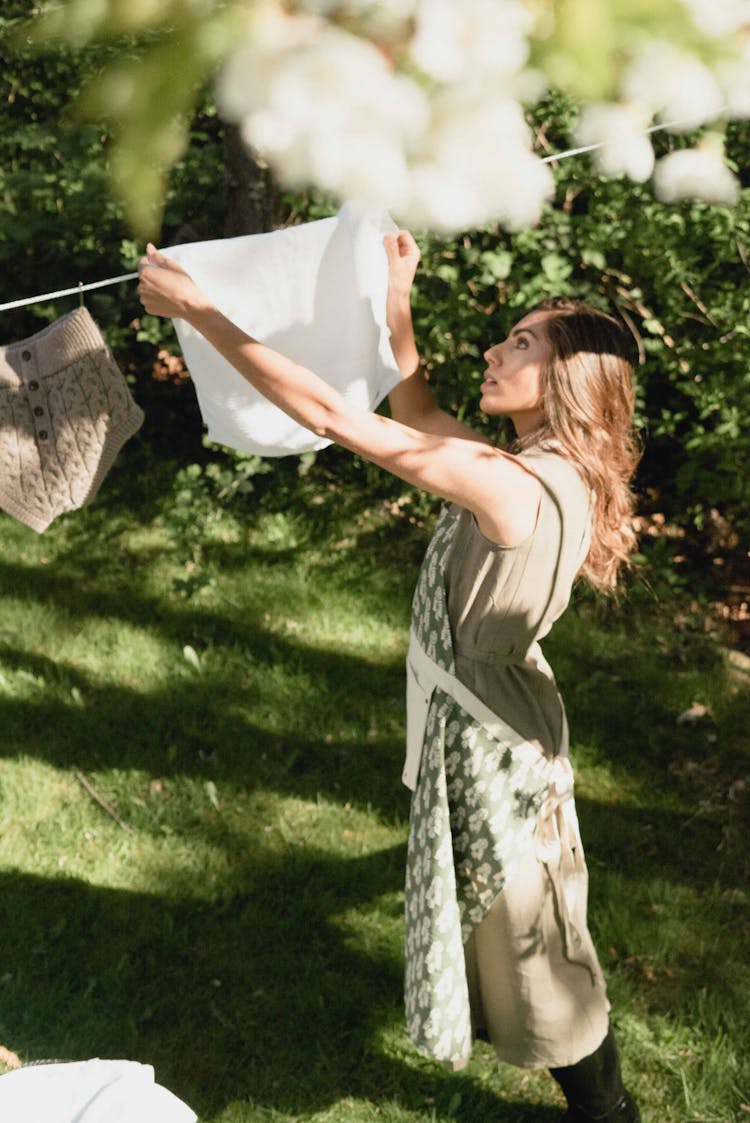 Woman Hanging Laundry In The Garden 