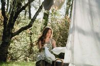 A Woman in Green Dress Folding Laundry