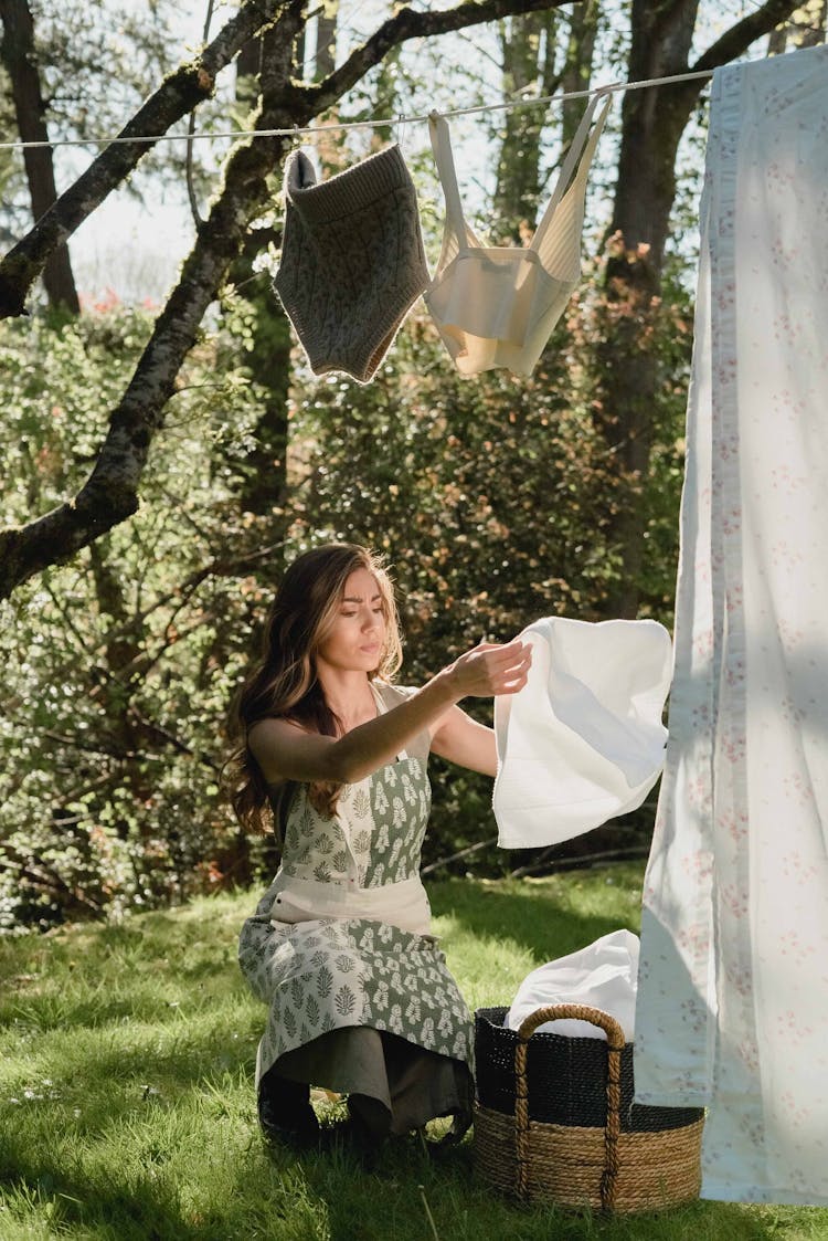 A Woman Hanging Clothes On A Clothes Line