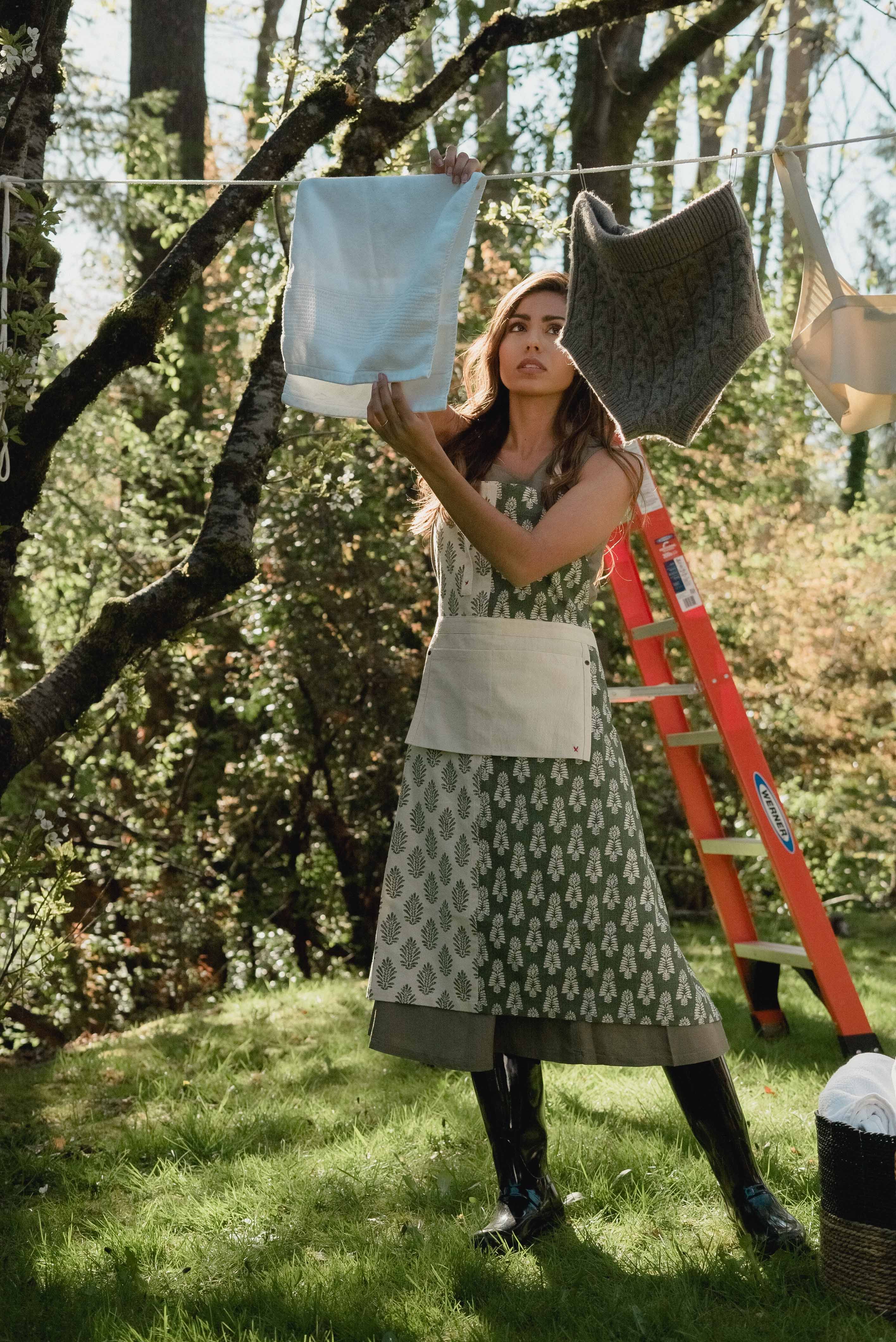 A Woman Wearing an Apron Doing Laundry · Free Stock Photo