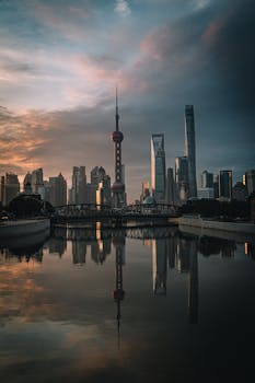 Stunning sunrise view of Shanghai's skyline reflecting on the river, highlighting iconic landmarks.