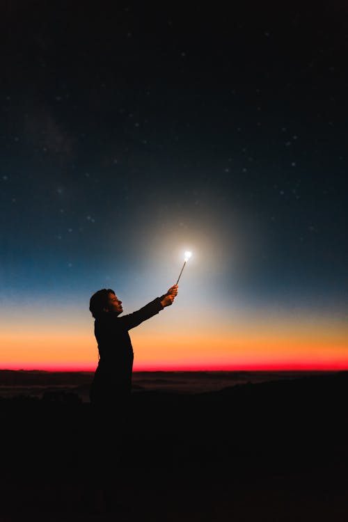 Free Person Holding Roman Candle at Night Stock Photo