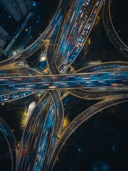 Aerial view of illuminated highways in Shanghai at night, showcasing vibrant traffic flow.