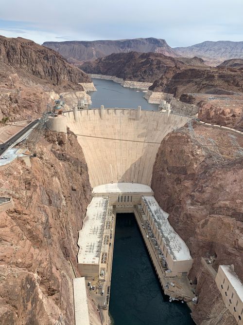 Free Drone shot of Hoover Dam along the Colorado River showcasing its architecture. Stock Photo