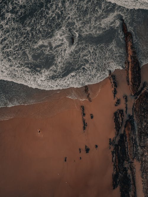 Drone Shot of Waves Crashing on the Sandy Shore