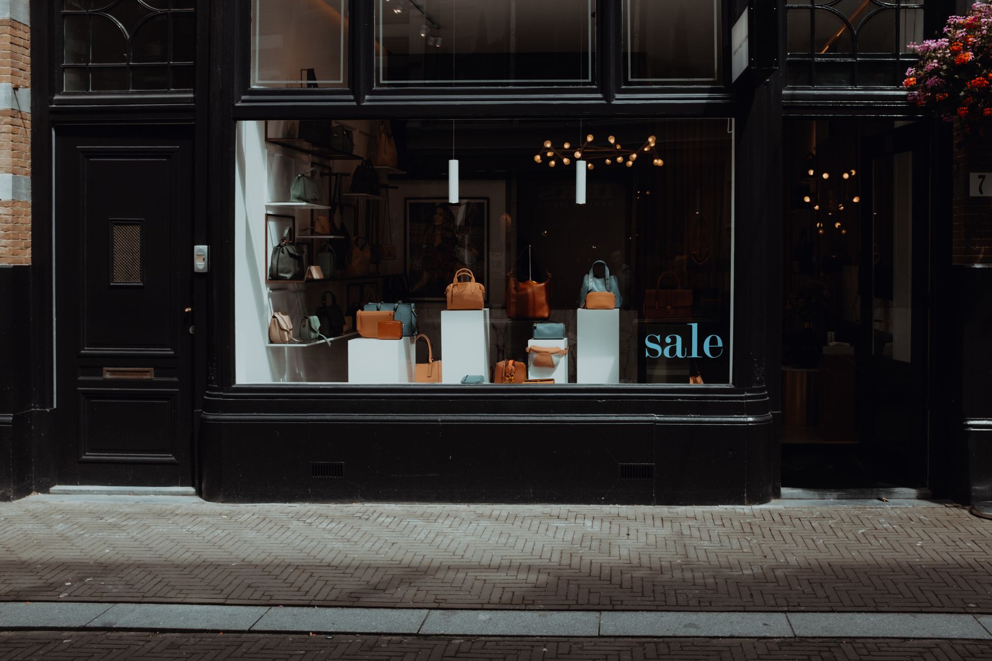 Stylish boutique storefront featuring elegant handbags on sale, inviting window display.