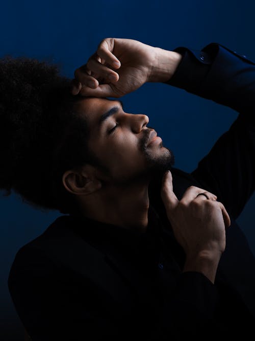 A Profile of a Man in Black Jacket Posing with Hand on Forehead