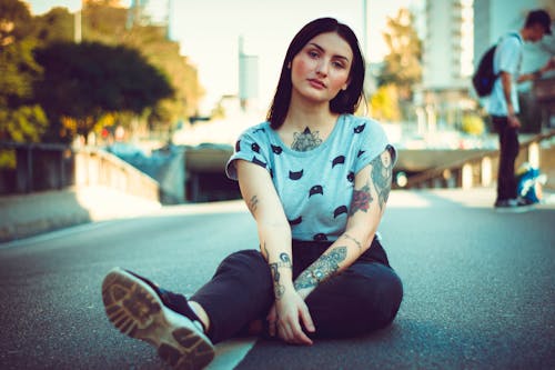 Tattooed Woman Sitting on the Ground 
