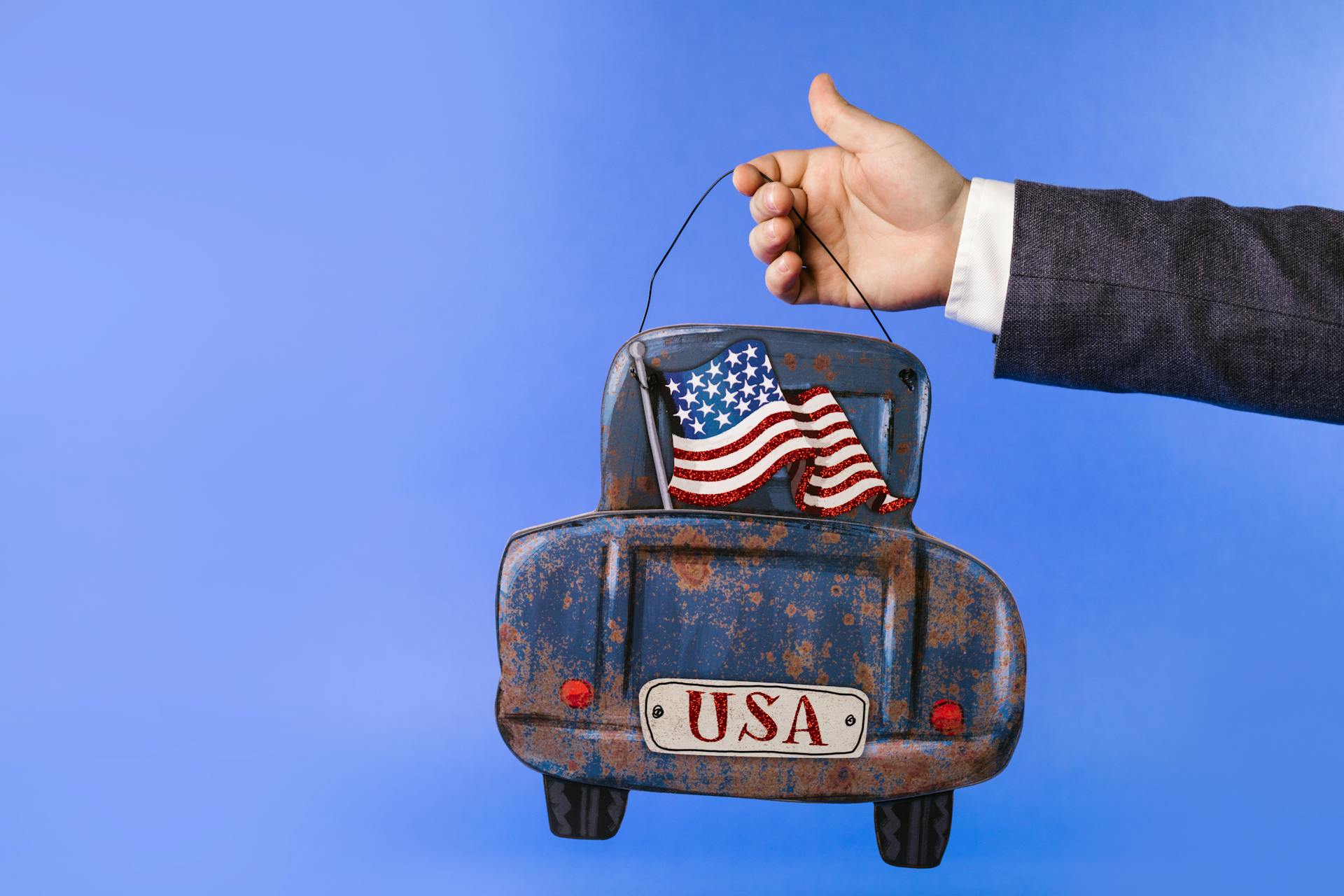 A Person Holding a Rusty Home Decoration with American Flag and USA Design