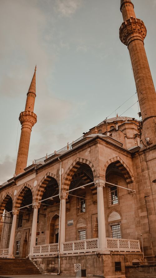 Free Elegant mosque facade with minarets under a clear sky, showcasing Islamic architecture. Stock Photo