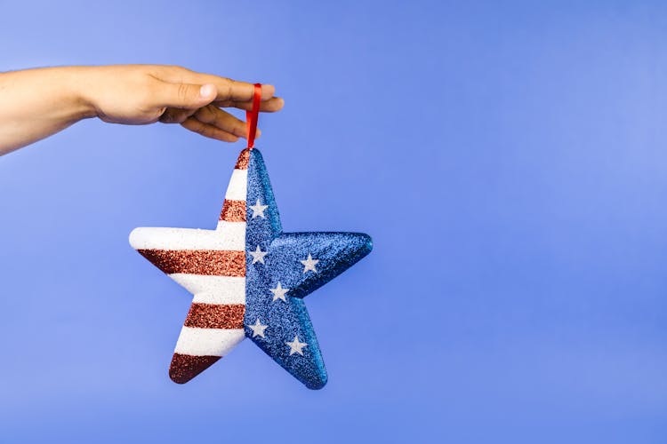 A Person Holding A Glittery Star Shape Decoration