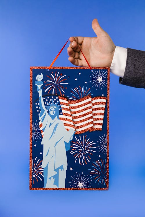 A Person Holding a Hanging Banner with the Fourth of July Background