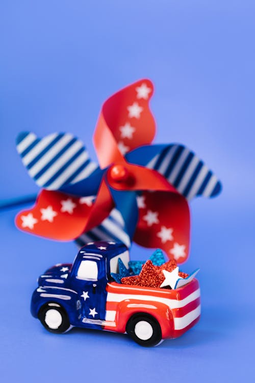 A Pinwheel and Toy Truck With Stars and Stripes Design