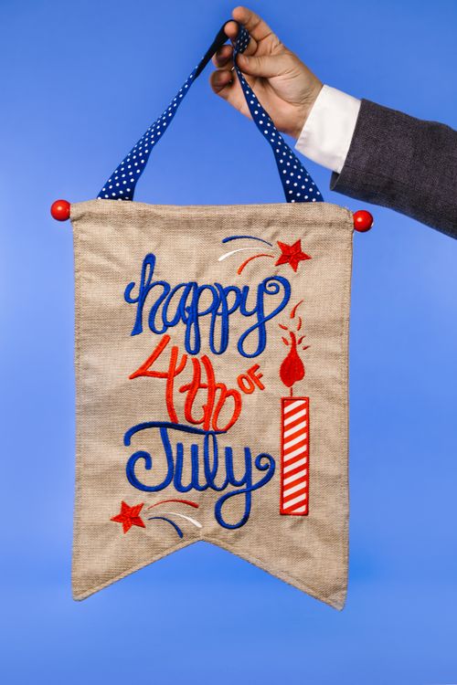 Free Patriotic hand-held banner with embroidery for Independence Day. Stock Photo