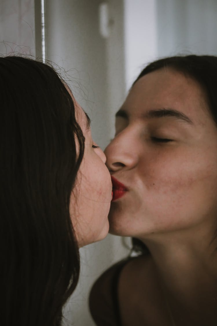   A Woman With Red Lipstick Kissing With Reflection In A Mirror