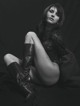 Grayscale studio portrait of a stylish woman posing with poise, embodying elegance and confidence.