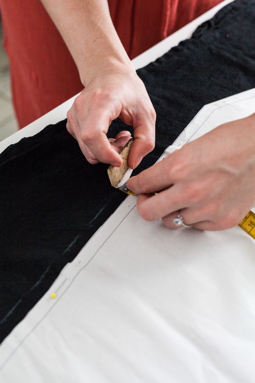 Free Close-up of a tailor using chalk to trace a pattern on fabric in a workspace. Stock Photo