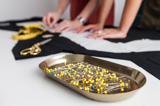 Pins on Steel Container With Background of People Making a Pattern on Textile