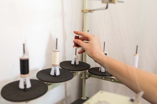 A Person Putting Thread on a Spool Pin