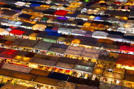 Colorful aerial shot of a bustling night market in Bangkok, Thailand, showcasing vibrant stalls.