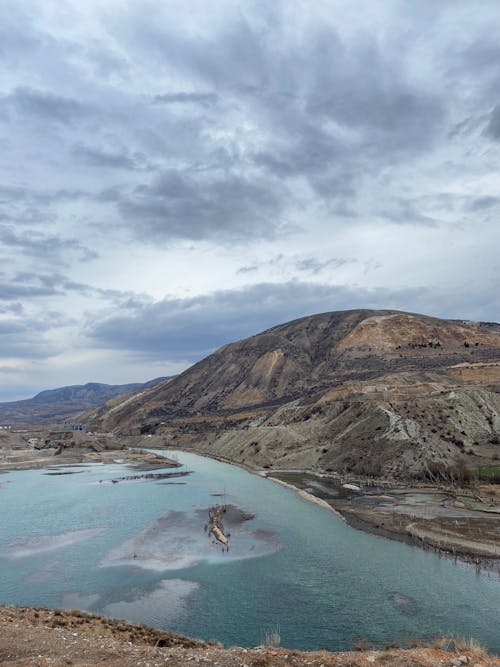 Cloudy Sky above Mountain and Body of Water