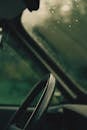 Car wheel near wet window with drops