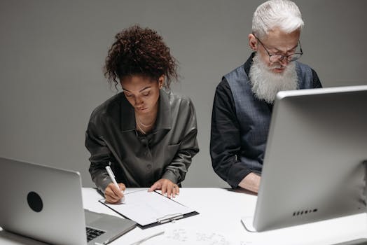 Diverse coworkers in office workspace engaging in focused teamwork and note-taking.