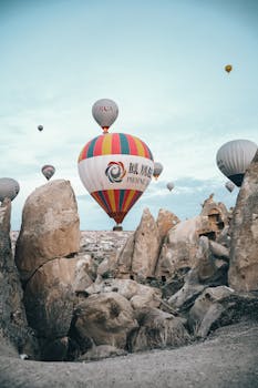 Captivating hot air balloons soaring over unique rock formations in Cappadocia, Turkey at dawn.