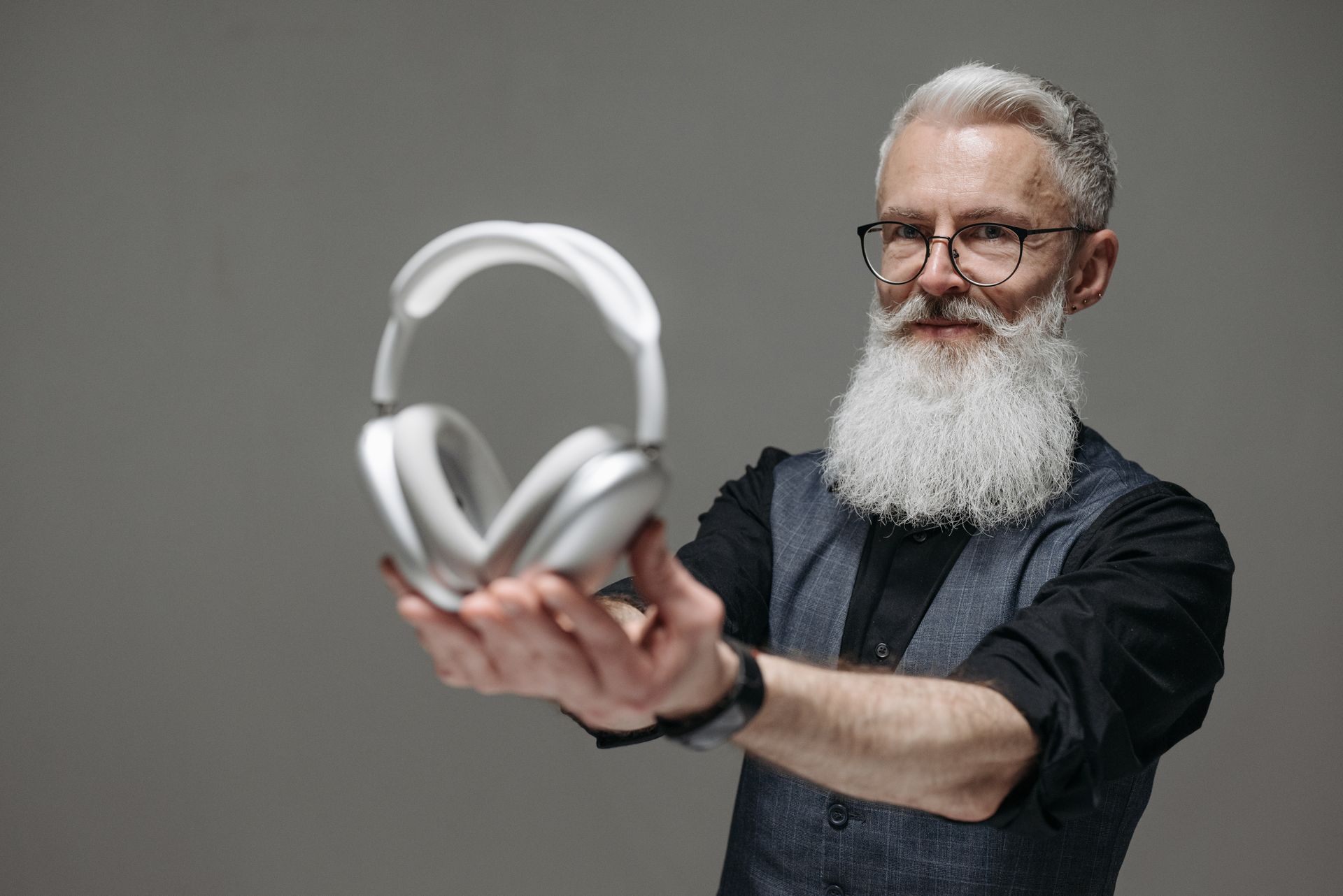 A Bearded Businessman Holding Wireless Headphones