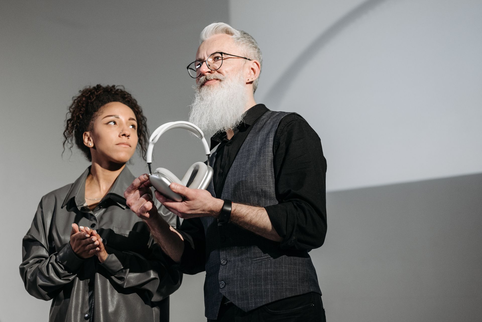 Man and woman presenting new headphone design at a business event.