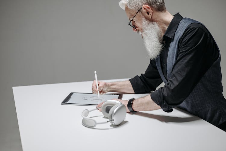 A Man Holding A Stylus Pen Drawing On A Tablet