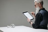 Man in Black Long Sleeve Shirt Holding White Ipad