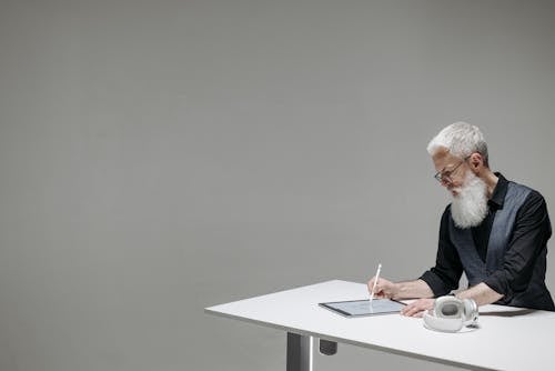 Free A Bearded Businessman Drawing on a Tablet with a Stylus Stock Photo